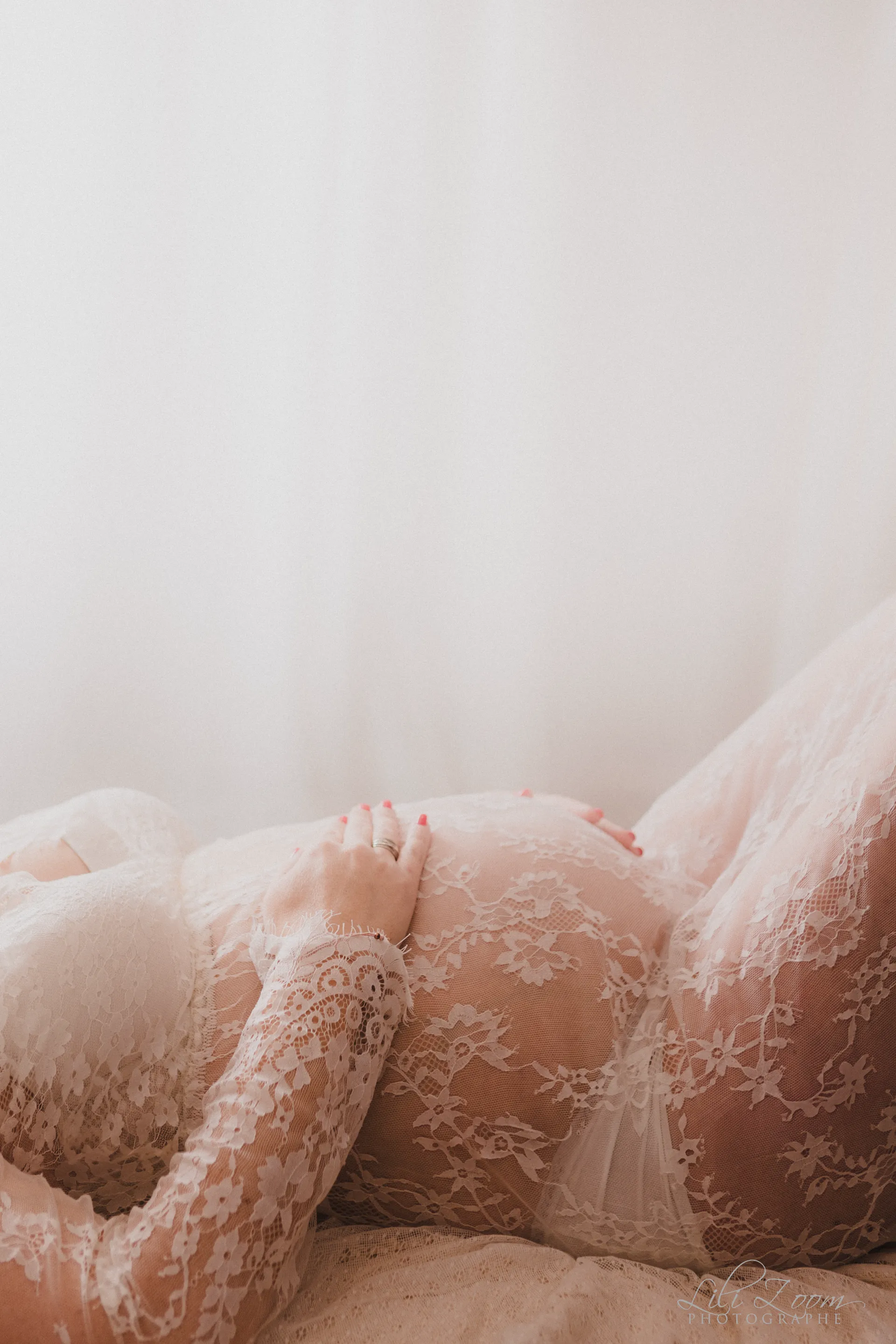 Séance tout en douceur pour une futur maman qui pose ses mains sur son ventre arrondi, séance grossesse au studio photo de Giberville