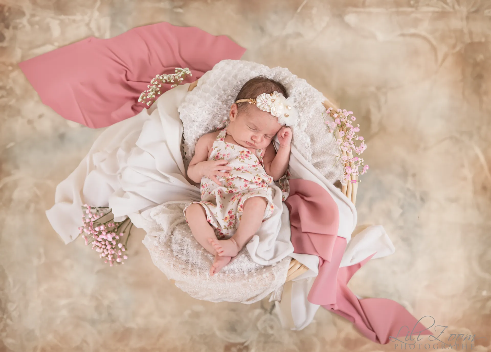Nouveau-né paisiblement endormi dans un panier fleuri aux teintes douces et printanières - Photographe Naissance à Giberville