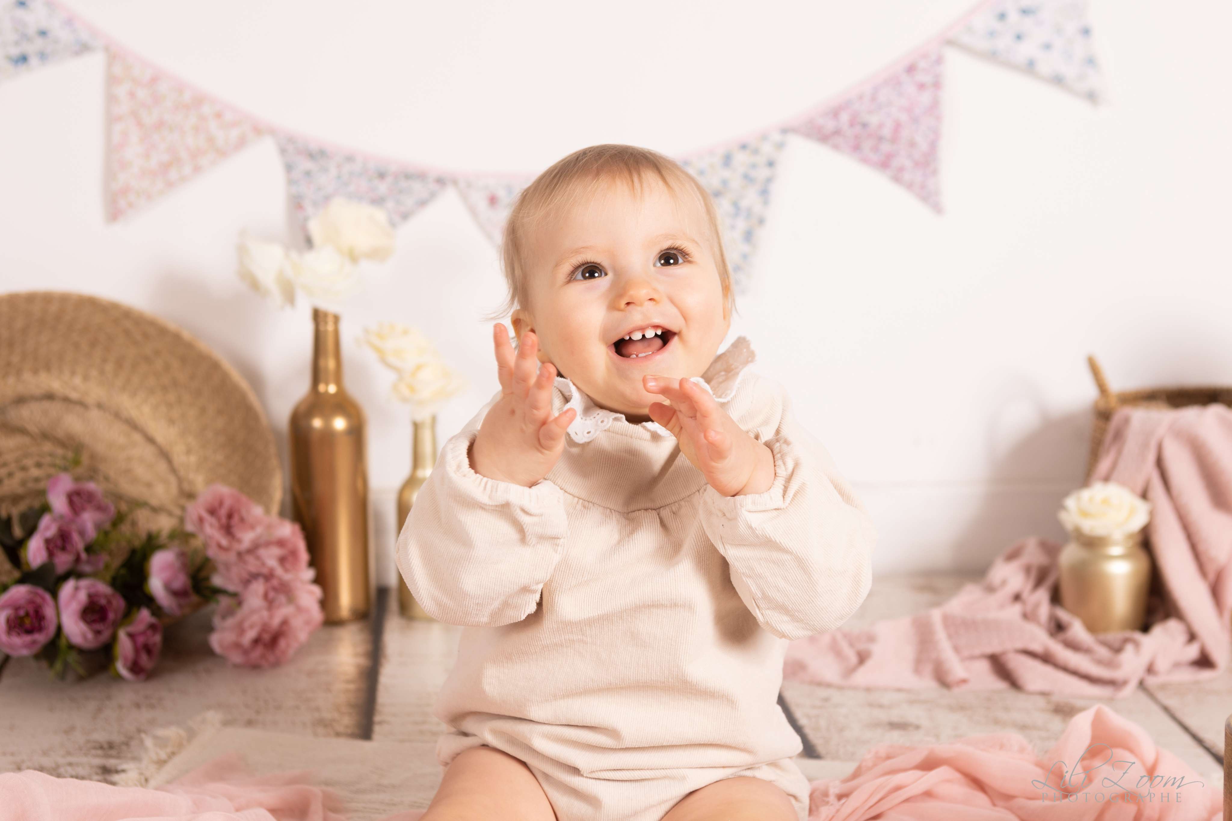 Un bébé pose au studio en petite tenue, il sourie et rigole pour la photographie en Normandie