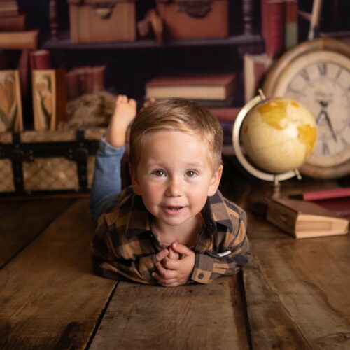 Petit garçon allongé dans une bibliothèque, décor vintage, séance photo enfant en Normandie
