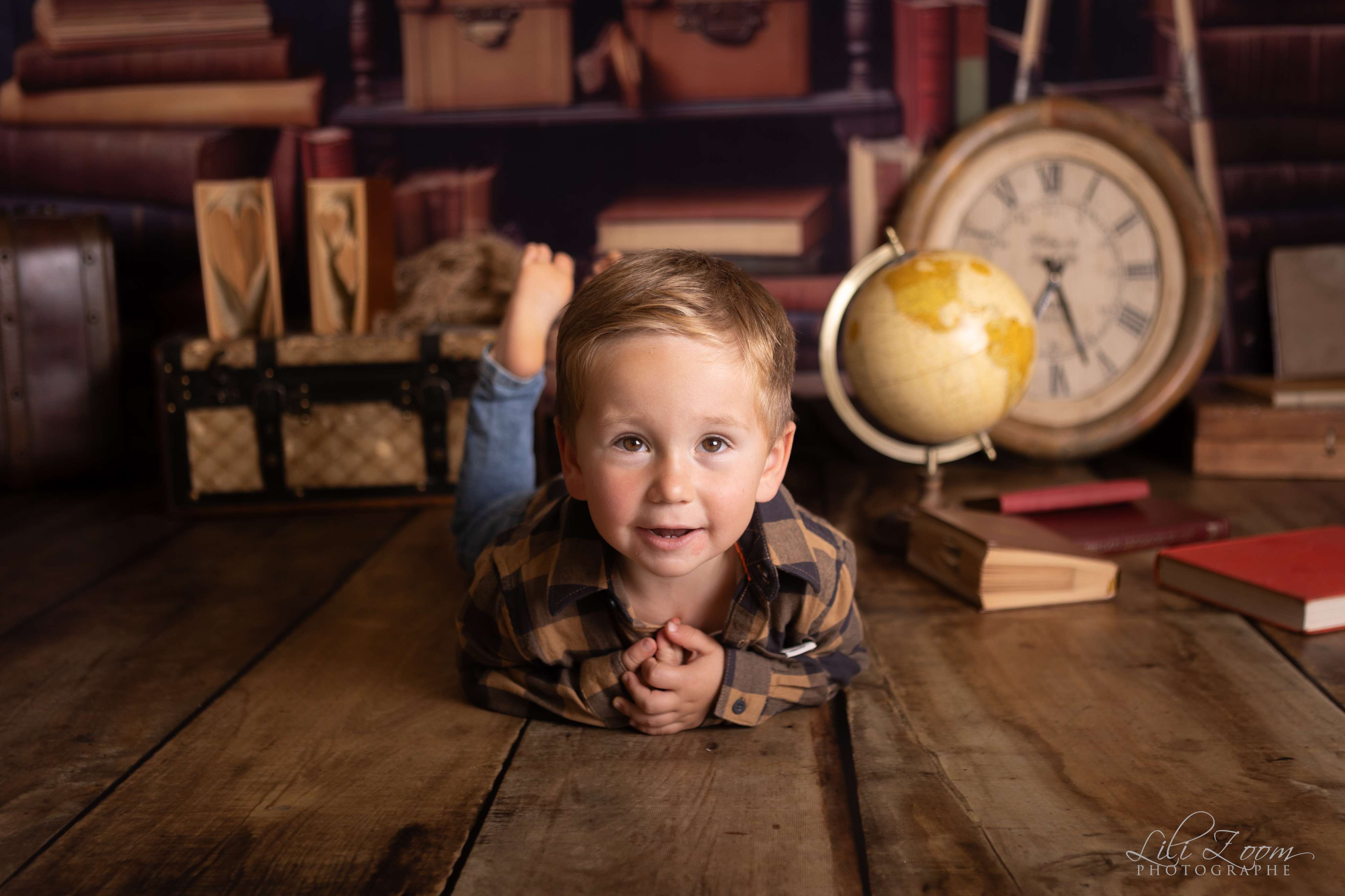 Petit garçon allongé dans une bibliothèque, décor vintage, séance photo enfant en Normandie