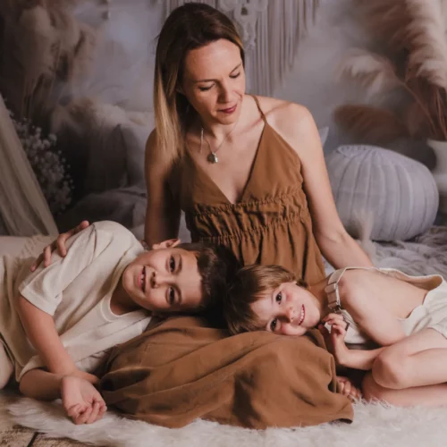 Moment de tendresse entre une mère et ses deux garçons dans un studio au décor bohème - Photographe Famille aux alentours de Colombelles