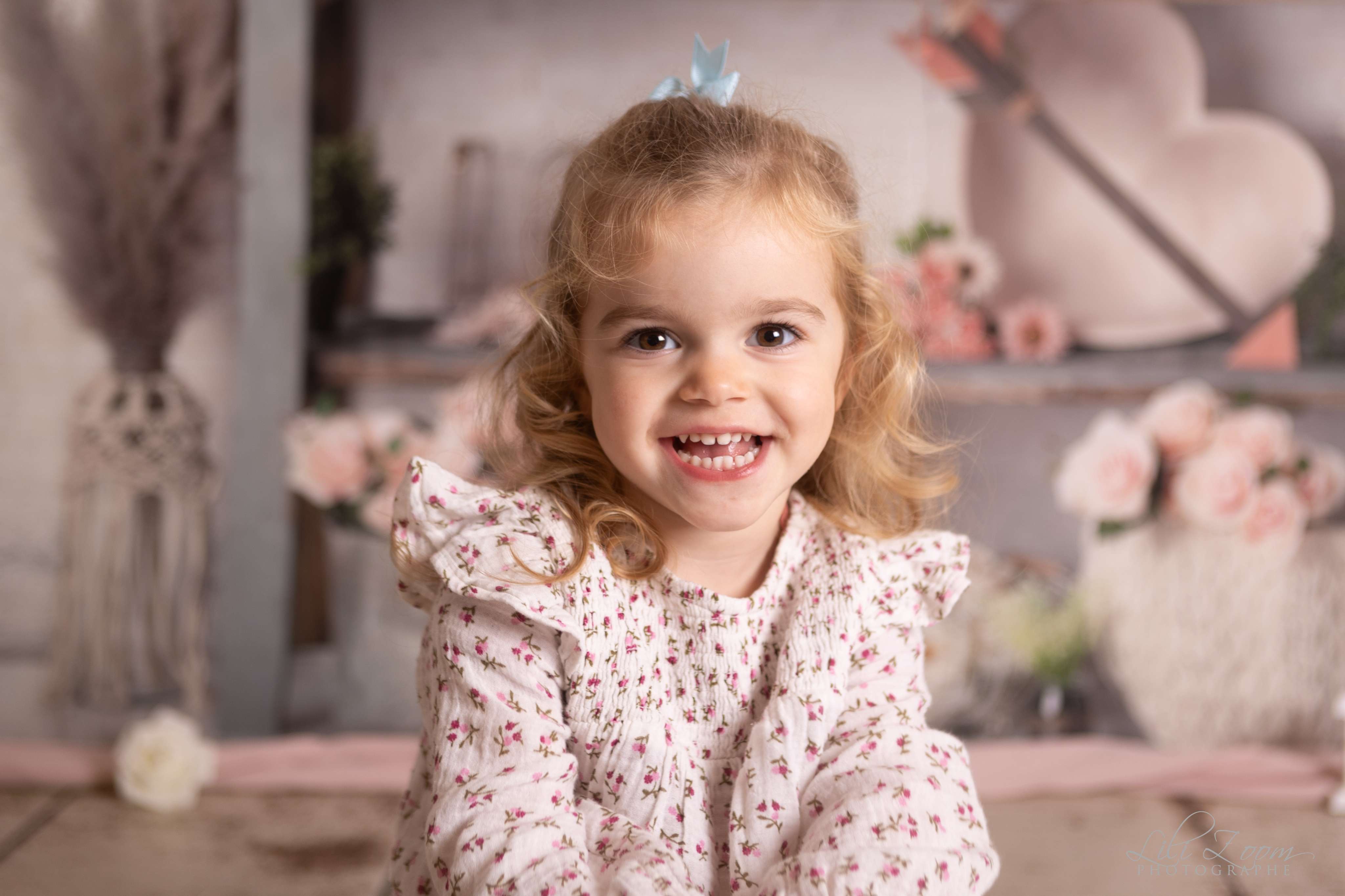 Une fillette aux cheveux bouclés avec des roses et des coeurs, séance photo famille enfant à Cuverville