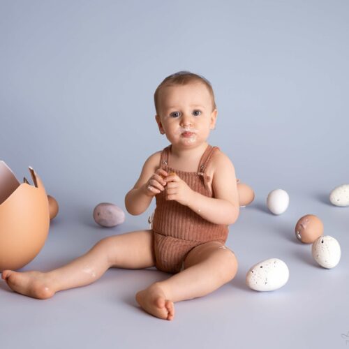Un petit garçon sort d'un oeuf, décoration de Pâques, séance photo à thème en Normandie