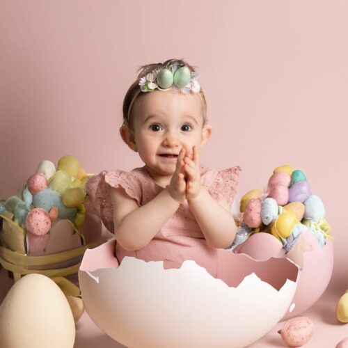 Un bébé avec un ruban dans un oeuf géant avec une décoration de Pâques, séance photo à thème sur Démouville