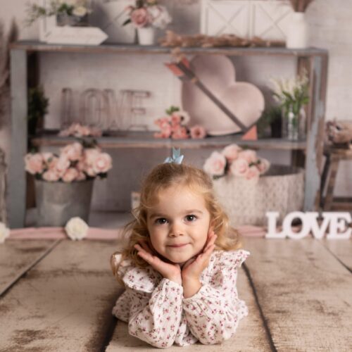 Une petite fille aux cheveux long fait un beau sourire dans un décor bohème, séance photo d'enfant à Caen