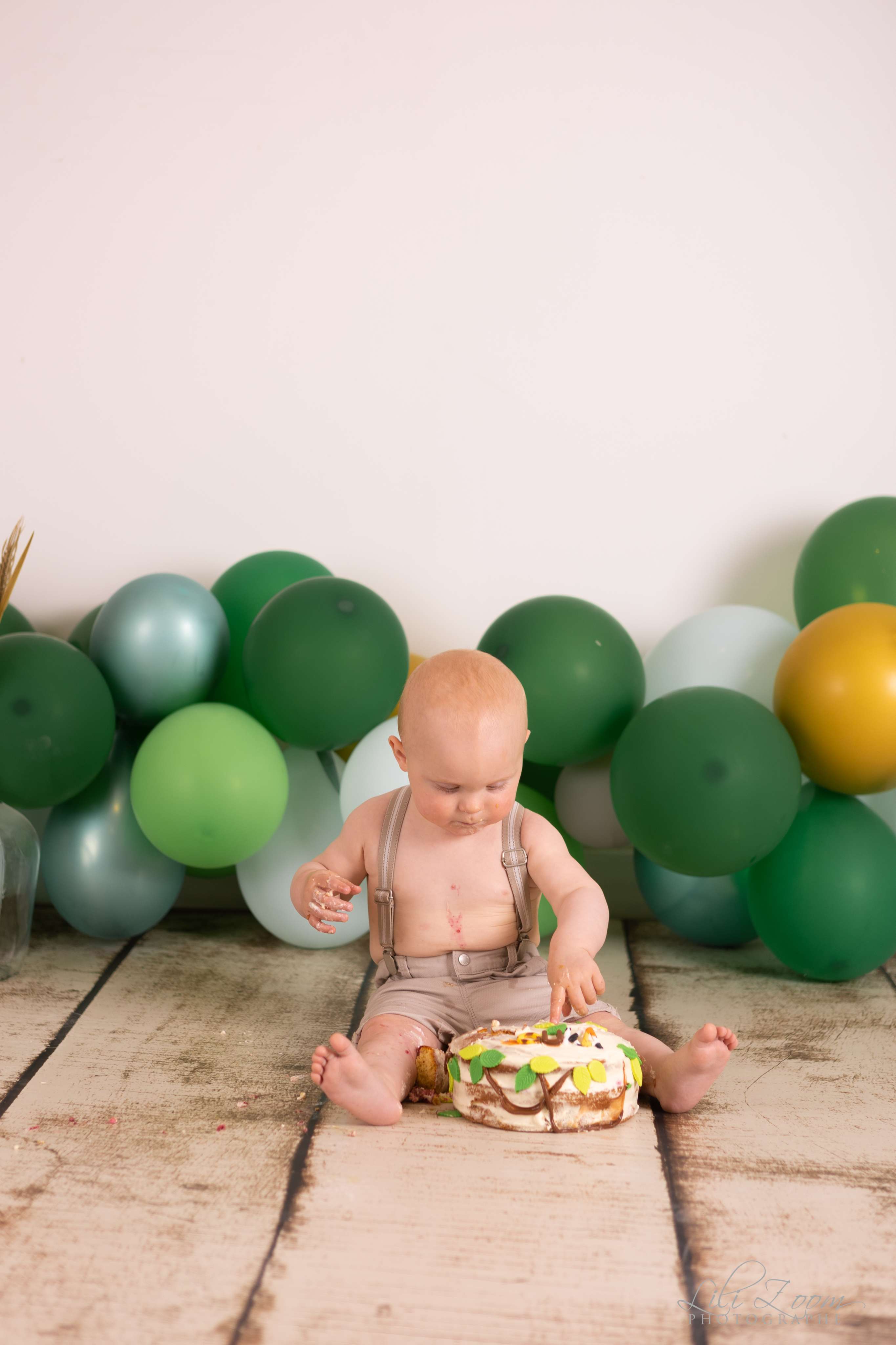 Un bébé fête son anniversaire dans un décor jungle, il smash the cake pendant un shooting photo à Caen