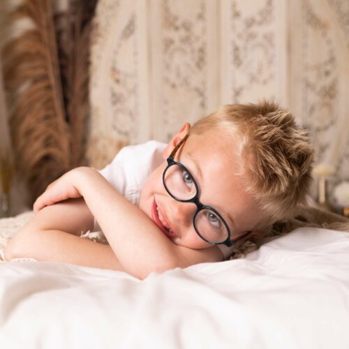 Un garçon à lunettes fait une séance photo bohème et décontractée pendant un shooting en Normandie