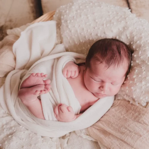 Nouveau-né paisiblement endormi et emmailloté dans un panier douillet aux tons naturels - Photographe Naissance secteur Hérouville-Saint-Clair