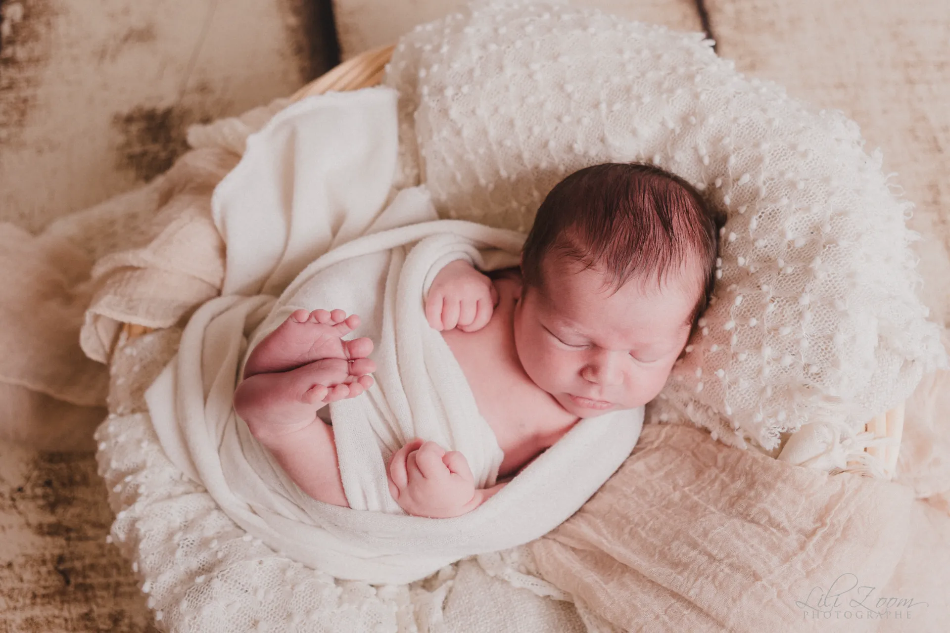 Nouveau-né paisiblement endormi et emmailloté dans un panier douillet aux tons naturels - Photographe Naissance secteur Hérouville-Saint-Clair