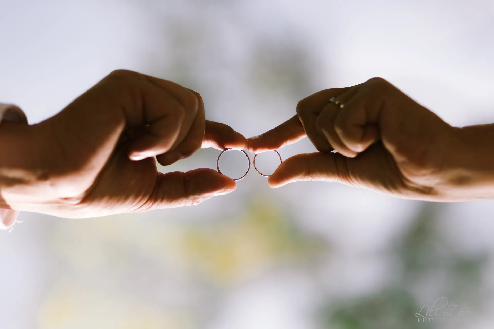 Mains des mariés tenant leurs alliances l'une contre l'autre - Photographe mariage Beuvron-en-Auge