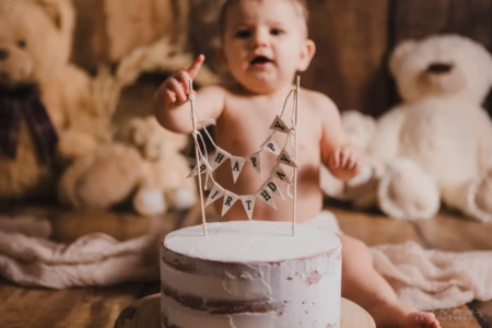 Bébé garçon curieux pointant du doigt son gâteau blanc avec guirlande Happy Birthday et ours en peluche - Studio professionnel proche Colombelles - Séance Anniversaire à Giberville. Bébé garçon curieux pointant du doigt son gâteau blanc avec guirlande Happy Birthday et ours en peluche - Studio professionnel proche Colombelles - Séance Anniversaire à Giberville.