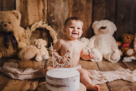 Bébé garçon rayonnant de bonheur devant son gâteau d'anniversaire entouré de peluches oursons - Séance Smash the Cake au Studio à Giberville. Bébé garçon rayonnant de bonheur devant son gâteau d'anniversaire entouré de peluches oursons - Séance Smash the Cake au Studio à Giberville.