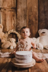 Bébé curieux et attendrissant assis devant son gâteau d'anniversaire entouré d'oursons en peluche - Séance Anniversaire studio professionnel proche Colombelles. Bébé curieux et attendrissant assis devant son gâteau d'anniversaire entouré d'oursons en peluche - Séance Anniversaire studio professionnel proche Colombelles.