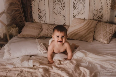 Bébé joyeux et spontané rampant sur un lit dans un décor bohème aux tons naturels - Studio professionnel proche Colombelles - Photographe Bébé à Caen. Bébé joyeux et spontané rampant sur un lit dans un décor bohème aux tons naturels - Studio professionnel proche Colombelles - Photographe Bébé à Caen.