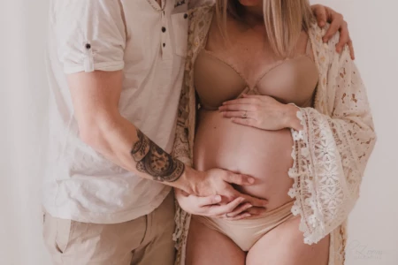 Mains d'un couple posées avec tendresse sur le ventre rond d'une femme enceinte, séance intime en studio - Photographe Grossesse secteur Mondeville Mains d'un couple posées avec tendresse sur le ventre rond d'une femme enceinte, séance intime en studio - Photographe Grossesse secteur Mondeville
