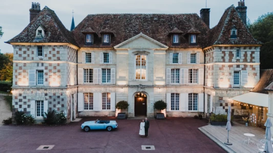 Couple de mariés devant un magnifique château illuminé avec une voiture ancienne bleue à la tombée de la nuit - Photographe Famille à Caen Couple de mariés devant un magnifique château illuminé avec une voiture ancienne bleue à la tombée de la nuit - Photographe Famille à Caen
