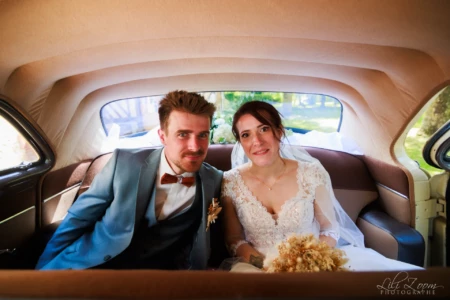 Portrait complice de jeunes mariés à l'arrière d'une voiture de collection vintage, robe en dentelle et bouquet champêtre - Photographe Mariage et Famille à la Vallée des Jardins Portrait complice de jeunes mariés à l'arrière d'une voiture de collection vintage, robe en dentelle et bouquet champêtre - Photographe Mariage et Famille à la Vallée des Jardins