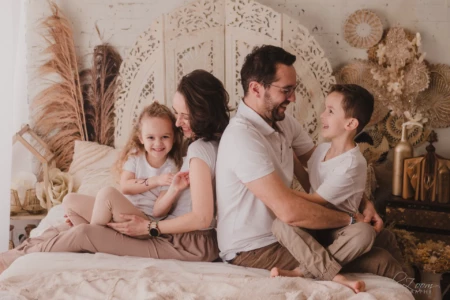 Rires et complicité d'une famille unie dans un décor studio bohème et chaleureux - Photographe Famille à Giberville Rires et complicité d'une famille unie dans un décor studio bohème et chaleureux - Photographe Famille à Giberville