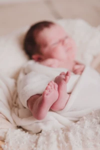 Gros plan artistique sur les pieds d'un nouveau-né emmailloté dans un cocon de douceur - Photographe Naissance à Caen Gros plan artistique sur les pieds d'un nouveau-né emmailloté dans un cocon de douceur - Photographe Naissance à Caen