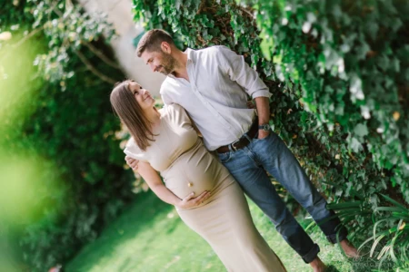 Futurs parents complices se regardant avec tendresse dans un jardin verdoyant - Photographe Grossesse Prairie de Caen Futurs parents complices se regardant avec tendresse dans un jardin verdoyant - Photographe Grossesse Prairie de Caen