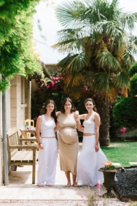 Femme enceinte entourée de deux jeunes femmes dans un jardin ensoleillé - Photographe grossesse Caen Femme enceinte entourée de deux jeunes femmes dans un jardin ensoleillé - Photographe grossesse Caen
