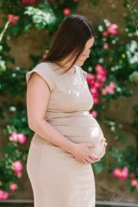 Future maman en robe beige tenant son ventre arrondi devant un rosier fleuri - Photographe grossesse ForĂȘt de Cinglais Future maman en robe beige tenant son ventre arrondi devant un rosier fleuri - Photographe grossesse ForĂȘt de Cinglais