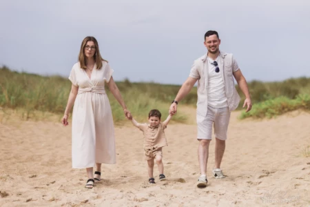 Jeune famille marchant main dans la main sur le sable - Photographe enfant famille Bernières-sur-Mer Jeune famille marchant main dans la main sur le sable - Photographe enfant famille Bernières-sur-Mer