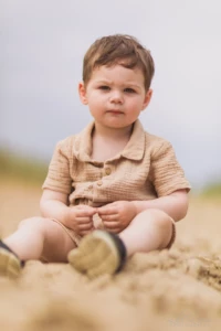 Petit garçon en ensemble beige assis dans le sable - Photographe enfant Côte Fleurie Petit garçon en ensemble beige assis dans le sable - Photographe enfant Côte Fleurie